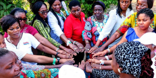 Black females of various ages touch fingertips in a circle